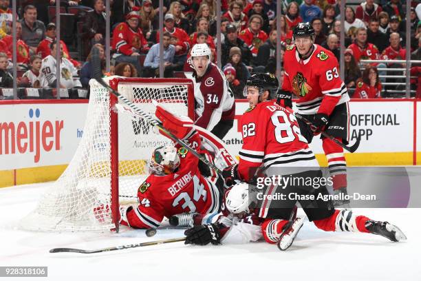 Jordan Oesterle of the Chicago Blackhawks falls on Matt Nieto of the Colorado Avalanche, as Carl Soderberg and Carl Dahlstrom watch in the...