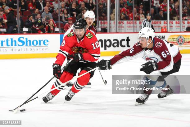 Patrick Sharp of the Chicago Blackhawks and Nail Yakupov of the Colorado Avalanche reach for the puck in the third period at the United Center on...