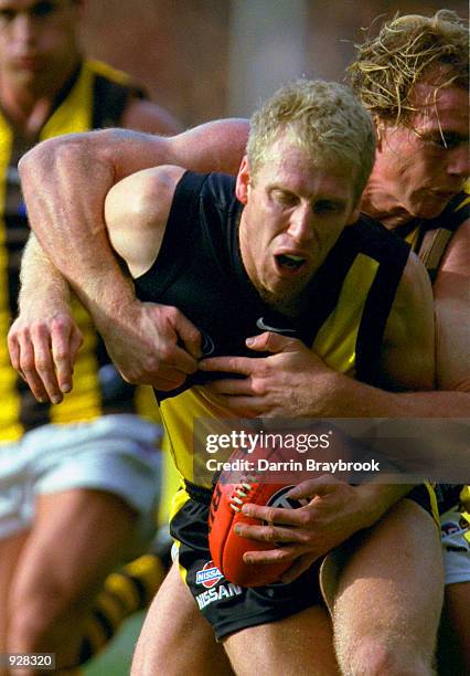 Matthew Knights of Richmond, has possession of the ball, and is tackled by Rayden Tallis of Hawthorn, during the match between the Richmond Tigers...