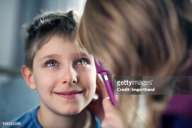 little boy is having eye exam at the ophthalmologist - child eyes stock pictures, royalty-free photos & images