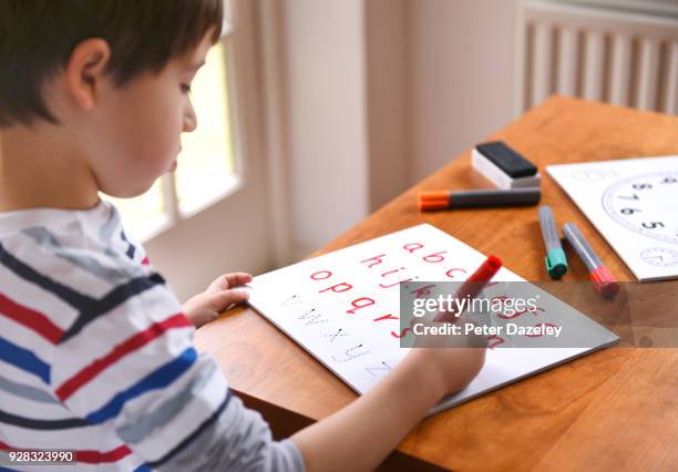 boy practicing writing the alphabet - copy writing stock-fotos und bilder