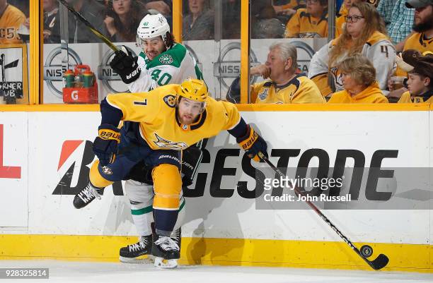 Yannick Weber of the Nashville Predators battles for the puck against Remi Elie of the Dallas Stars during an NHL game at Bridgestone Arena on March...