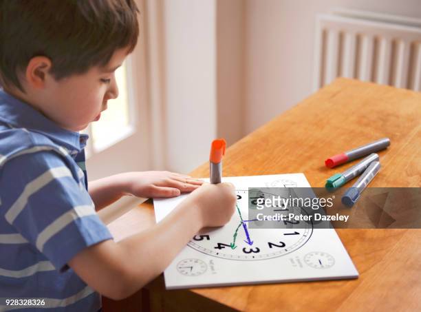 boy learning to tell the time - clocks go forward foto e immagini stock
