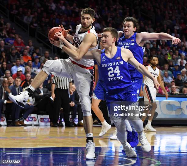 Killian Tillie of the Gonzaga Bulldogs is fouled as he drives to the basket against McKay Cannon and Payton Dastrup of the Brigham Young Cougars...