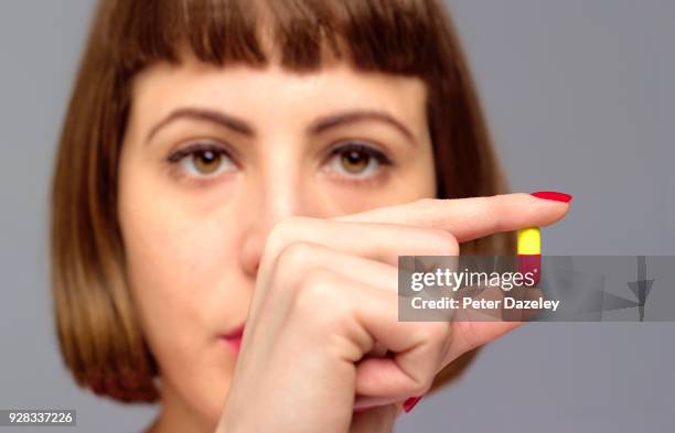 woman holding capsule - tomada de decisão imagens e fotografias de stock