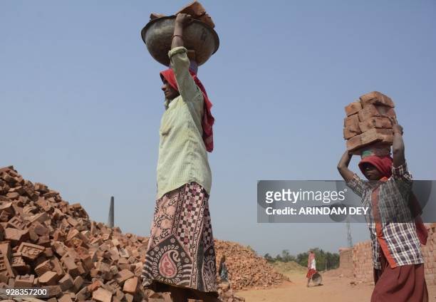 Indian labourers work at a brick kiln at Jirania in the outskirts of Agartala on March 7, 2018. / AFP PHOTO / Arindam DEY