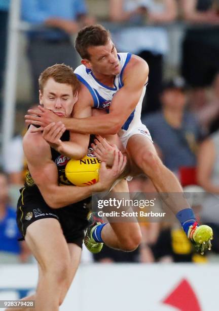 Kayne Turner of the Kangaroos and Jacob Townsend of the Tigers collide as they compete for the ball in the 2nd quarter during the AFL JLT Community...