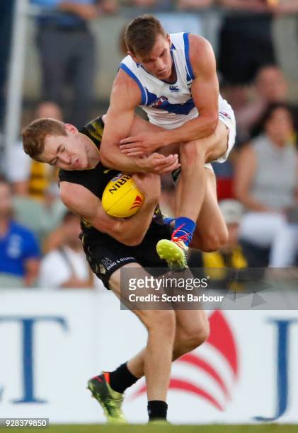 Kayne Turner of the Kangaroos and Jacob Townsend of the Tigers collide as they compete for the ball in the 2nd quarter during the AFL JLT Community...