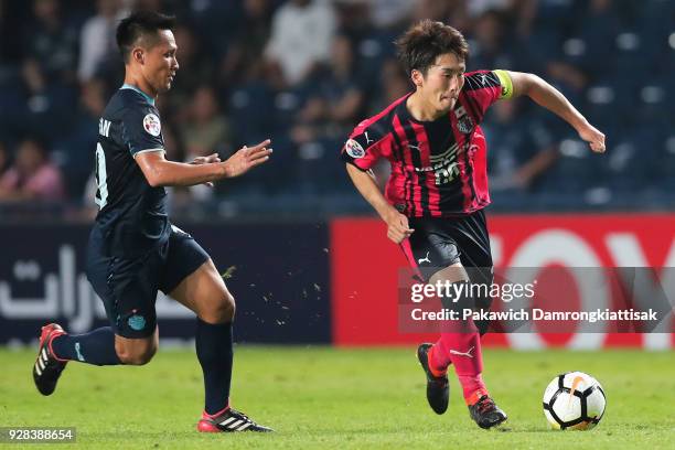 Daichi Akiyama of Cerezo Osaka dribbles the ball away from Jakkaphan Kaewprom of Buriram United FC during the AFC Champions League Group G match...