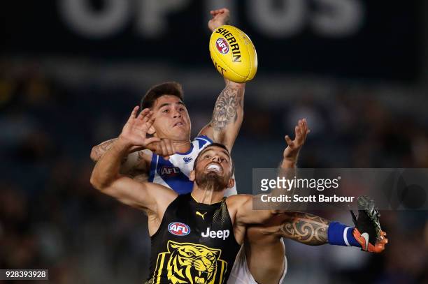 Marley Williams of the Kangaroos and Sam Lloyd of the Tigers compete for the ball during the AFL JLT Community Series match between the Richmond...