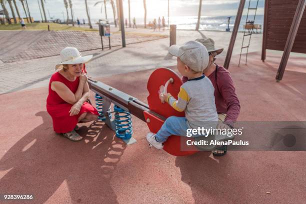 senior couple with their grandsan at the playground - playa de las americas stock pictures, royalty-free photos & images