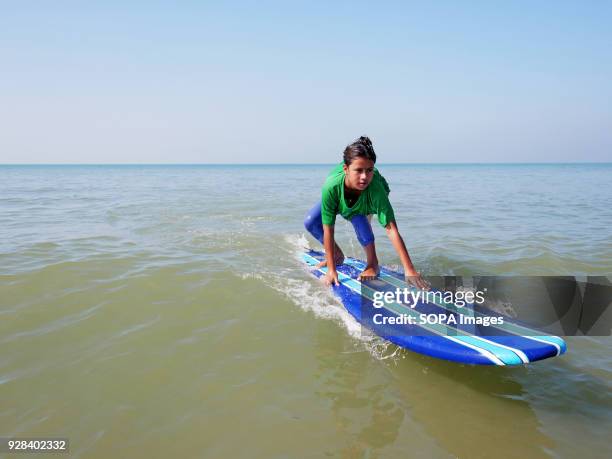 Young surfer seen practicing near the beach. Young people in the world´s longest sandy beach in Cox´s Bazar, Bangladesh, decided to throw away...