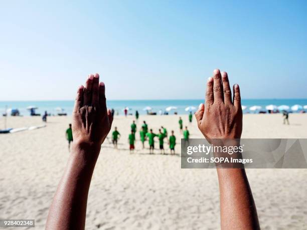 Surfing instructor seen leading the young surfer for warm up. Young people in the world´s longest sandy beach in Cox´s Bazar, Bangladesh, decided to...