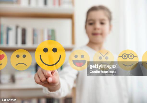 niña tocando el smiley emoji icono en la pantalla táctil - six faces fotografías e imágenes de stock