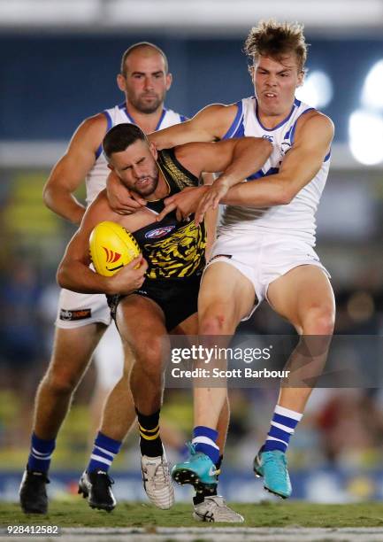 Jack Graham of the Tigers is tackled by Cameron Zurhaar of the Kangaroos during the AFL JLT Community Series match between the Richmond Tigers and...