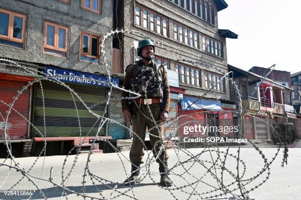 An Indian policeman stands guard during restrictions in Srinagar, Indian administered Kashmir. Authorities imposed restrictions in many parts of...