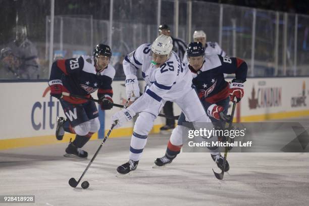 James van Riemsdyk of the Toronto Maple Leafs controls the puck against Jakub Jerabek and Jay Beagle of the Washington Capitals during Coors Light...