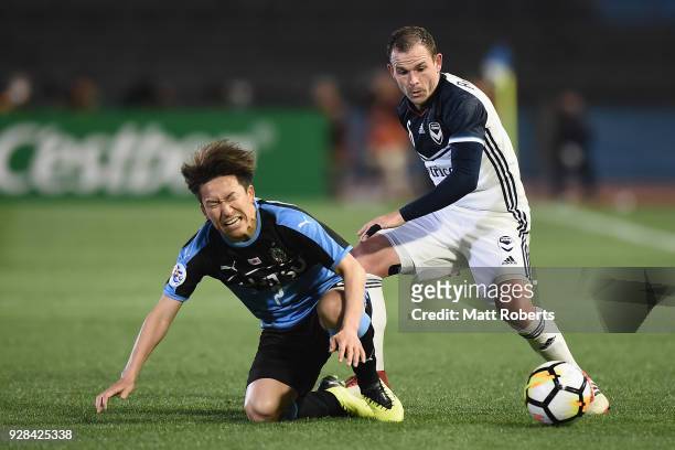 Leigh Broxham of Melbourne Victory tackles Kyohei Noborizato of Kawasaki Frontale during the AFC Champions League Group F match between Kawasaki...