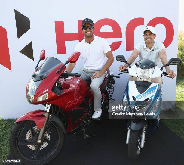 Sebastien Gros and Adrien Saddier of France sit on motorbikes, as they wait to tee off on the 16th hole during a practice round ahead of the Hero...