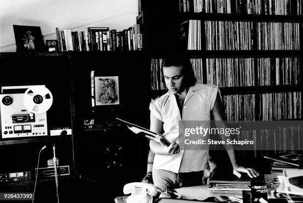 View of British musician and lyricist Bernie Taupin as he looks at a record in his home office, Los Angeles, California, April 1980.