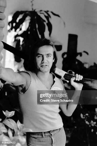 Portrait of British musician and lyricist Bernie Taupin as he poses with a shotgun on his shoulder, Los Angeles, California, April 1980.