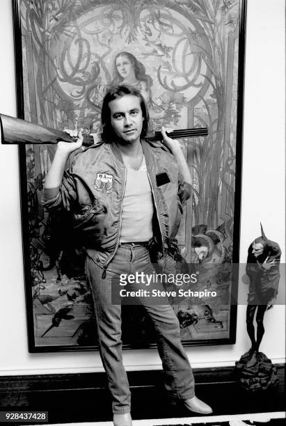 Portrait of British musician and lyricist Bernie Taupin as he poses with a shotgun over his shoulders, Los Angeles, California, April 1980.
