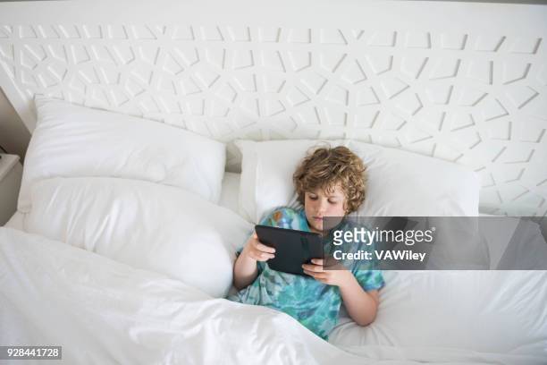young child sits in bed sick while trying to rest - calcification stock pictures, royalty-free photos & images