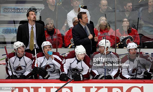 Head Coach Joe Sacco and Steve Konowalchuk of the Colorado Avalanche look on from the bench area during their game against the Calgary Flames on...