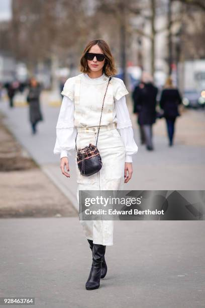 Candela Novembre wears a white dress, sunglasses, a Chanel bag, black boots, outside Chanel, during Paris Fashion Week Womenswear Fall/Winter...