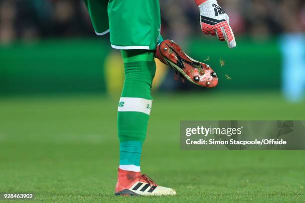 Liverpool goalkeeper Loris Karius picks grass from the studs in his boots during the UEFA Champions League Round of 16 Second Leg match between...