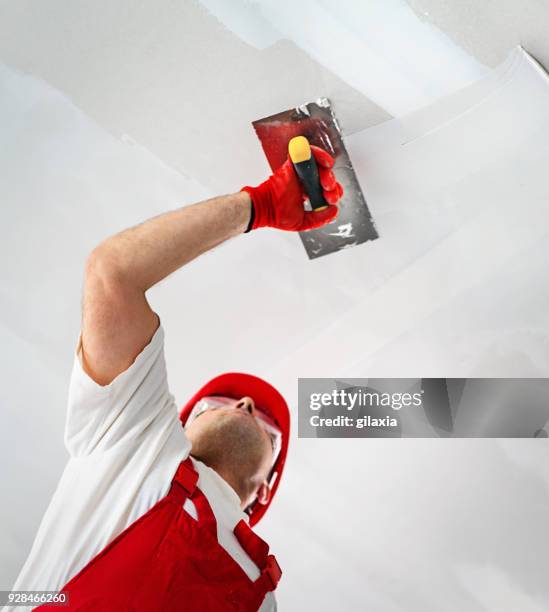 construction worker during interior decoration. - putting gloves stock pictures, royalty-free photos & images