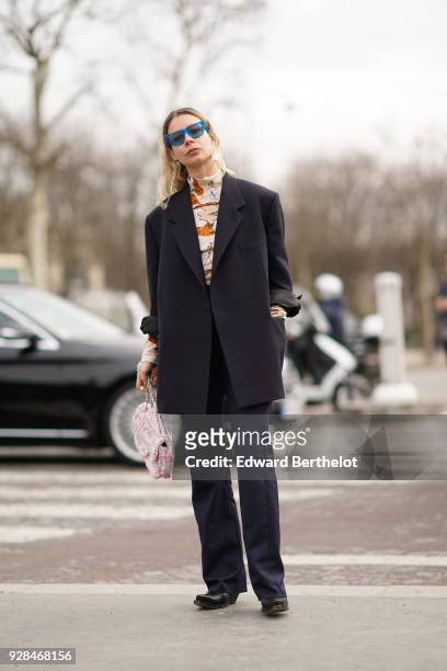 Irina Lakicevic wears a black blazer jacket, black pants, blue sunglasses , outside Chanel, during Paris Fashion Week Womenswear Fall/Winter...