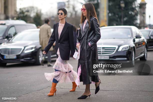 Yasmin Sewell wears a black blazer jacket, a pink lace dress, brown boots, jeans, outside Chanel, during Paris Fashion Week Womenswear Fall/Winter...