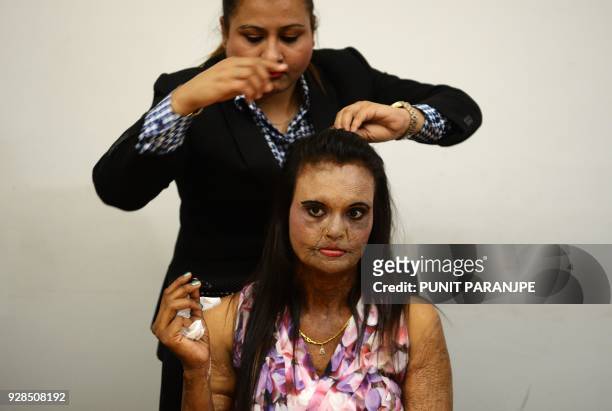 An Indian acid attack survivor gets her hair done before a fashion show as part of a campaign to spread the message 'Stop Acid Sale', in Thane on...