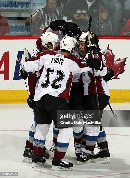 Ryan Wilson, Adame Foote and Paul Stastny of the Colorado Avalanche celebrate a play during a break in game action against the Calgary Flames on...