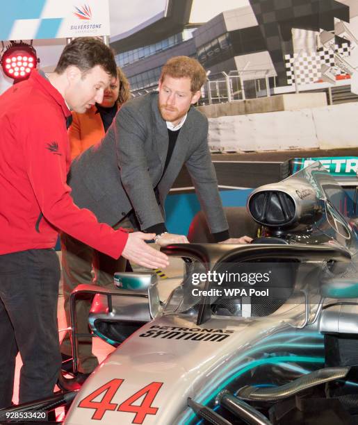 Prince Harry studies "The Halo" on Lewis Hamilton's Mercedes, which is a new addition to F1 cars this season, during his visit to the Silverstone...