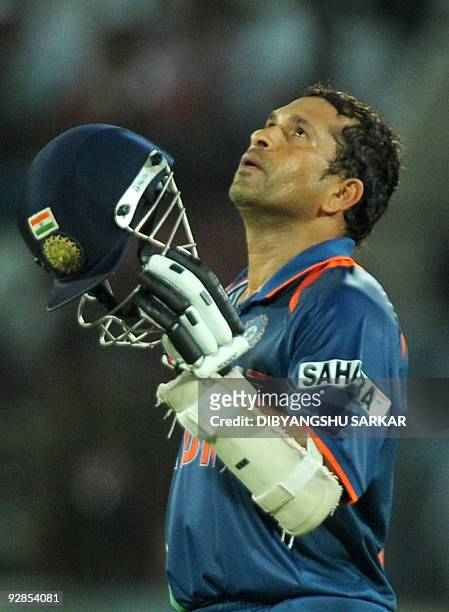 Indian cricketer Sachin Tendulkar celebrates after scoring a century during the fifth One-Day International between India and Australia at the Rajiv...