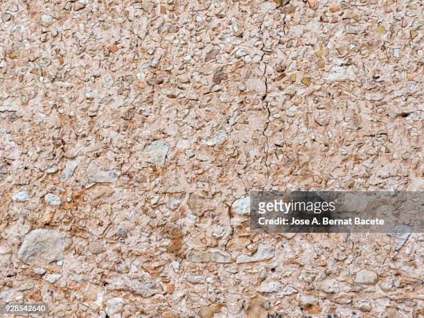 full frame of a facade of a stone wall with bricks ancient illuminated by the light of the sun. spain. high resolution photography. - adobe texture stockfoto's en -beelden