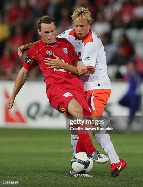 Kristian Sarkies of United is tackled by Mitch Nichols of Roar during the round 10 A-League match between Adelaide United and Brisbane Roar at...