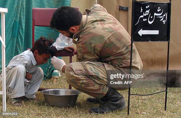 Pakistani Army paramedic gives treatment to a young internally displaced boy, fleeing from military operations against Taliban militants in South...