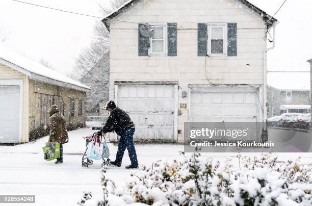 Pedestrians walk through snow on March 7, 2018 in Quakertown, Pennsylvania, This is the second nor'easter to hit the Northeast within a week and is...