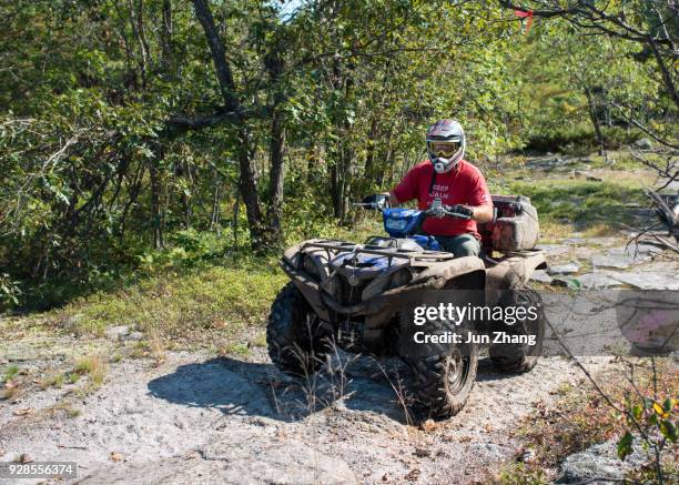 jongeman all - terrain voertuig rijden op rotsachtige bergtop in canada - eisberg stockfoto's en -beelden