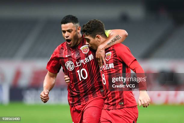 Oscar of Shanghai SIPG celebrates with team mate Hulk after scoring a goal during the AFC Champions League Group F match between Shanghai Shenhua and...