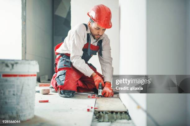 homme à tout faire poser des carreaux en céramique. - céramique photos et images de collection