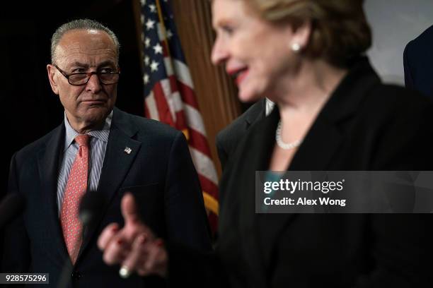 Sen. Debbie Stabenow speaks as Senate Minority Leader Sen. Chuck Schumer listens during a news conference at the Capitol March 7, 2018 in Washington,...