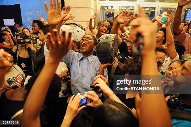 Woman holds up a radio as a crowd sings Michael Jackson songs after hearing of the death of the pop star June 25, 2009 in front of the Apollo Theater...