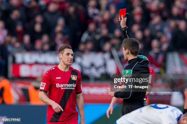 Referee Referee Daniel Siebert shows a yellow red card to Dominik Kohr of Leverkusen during the Bundesliga match between Bayer 04 Leverkusen and FC...