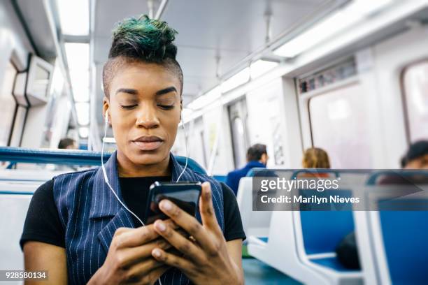 hip black businesswoman texting while sitting in the train - mohawk stock pictures, royalty-free photos & images