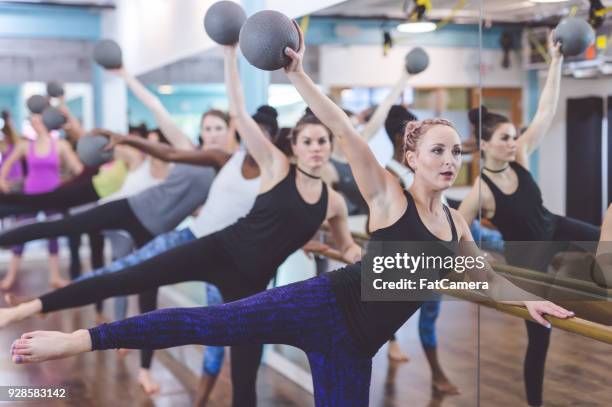 women doing barre workout together - pike position stock pictures, royalty-free photos & images