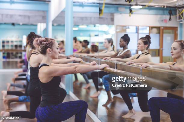 women doing barre workout together - pike position stock pictures, royalty-free photos & images